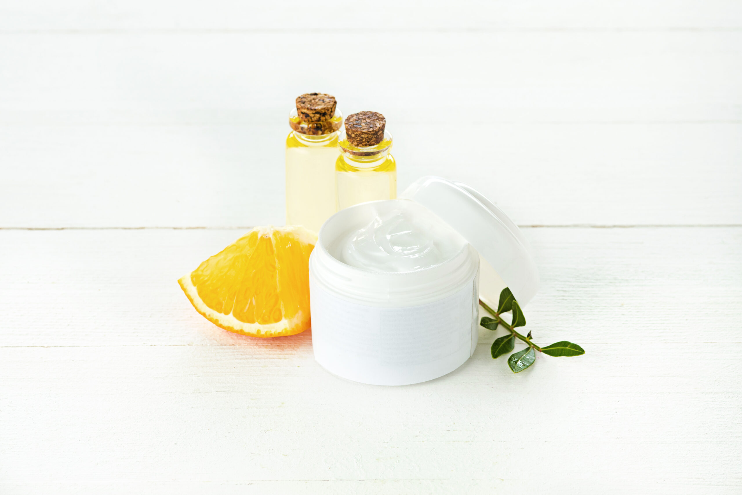 Spa concept with salt, mint, lotion, towel on white wooden background